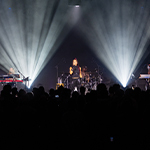 Crystal Kay performs under bright stage lights at Full Sail Live, backed by her band as the audience watches and records the show.