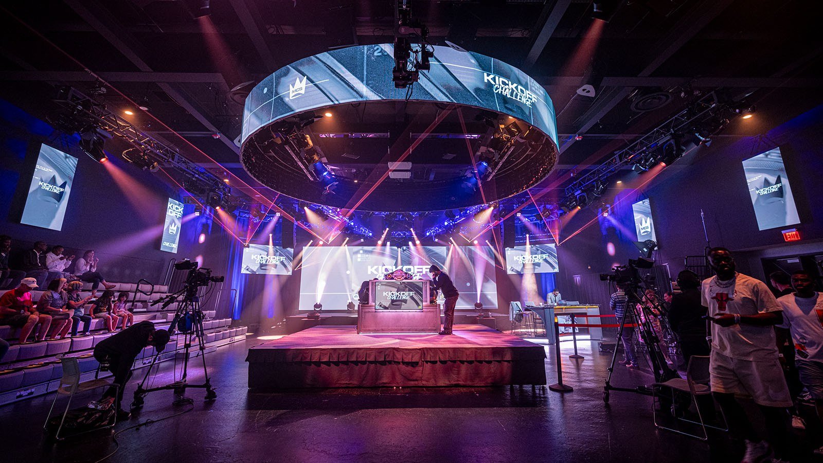Full Sail’s Fortress dressed for the MCS 25 Kickoff Challenge with dramatic lighting, camera crews, and a small audience watching.