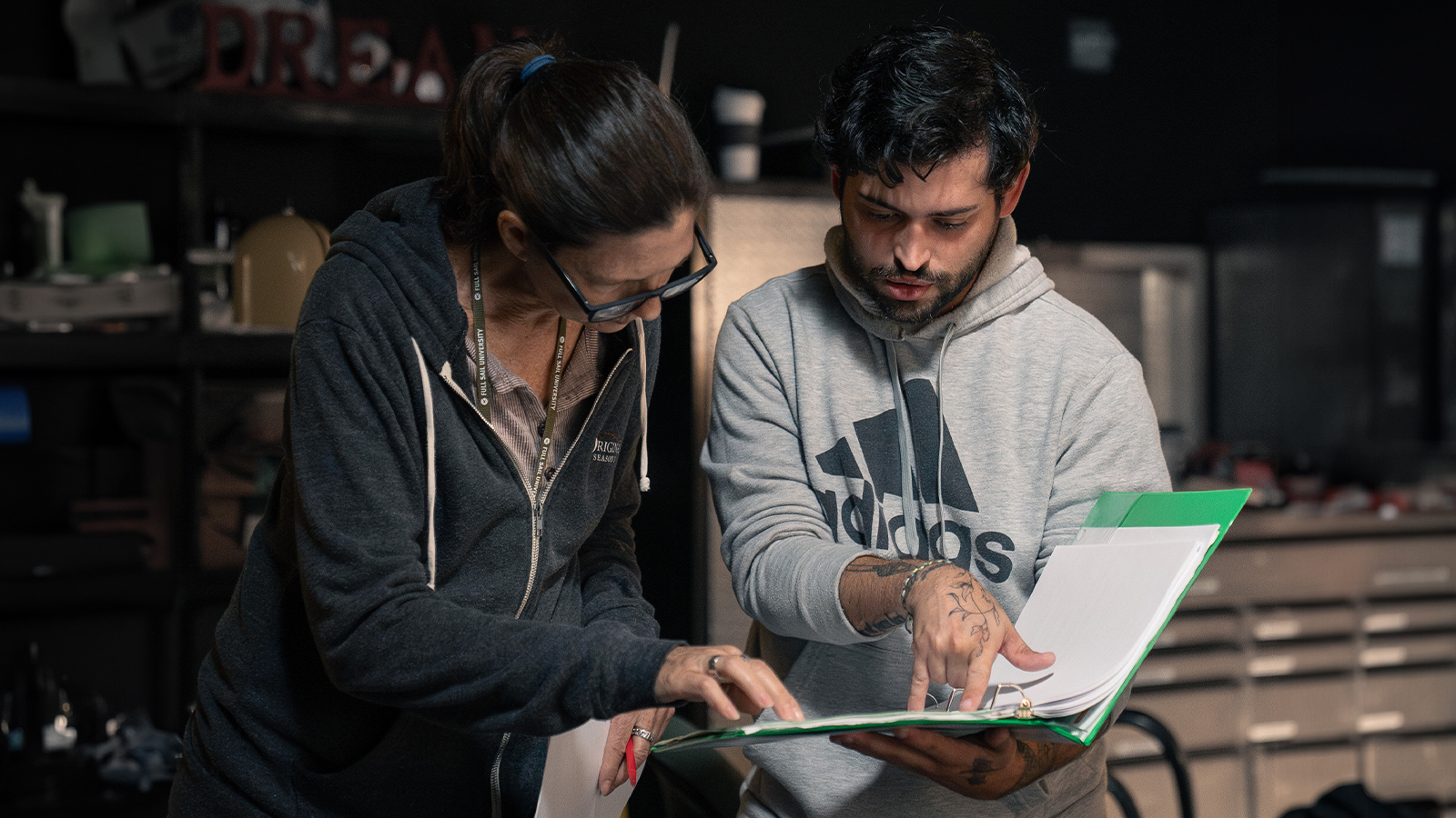 Deborah Walters helps student script supervisor Ryan Bessette with script on set
