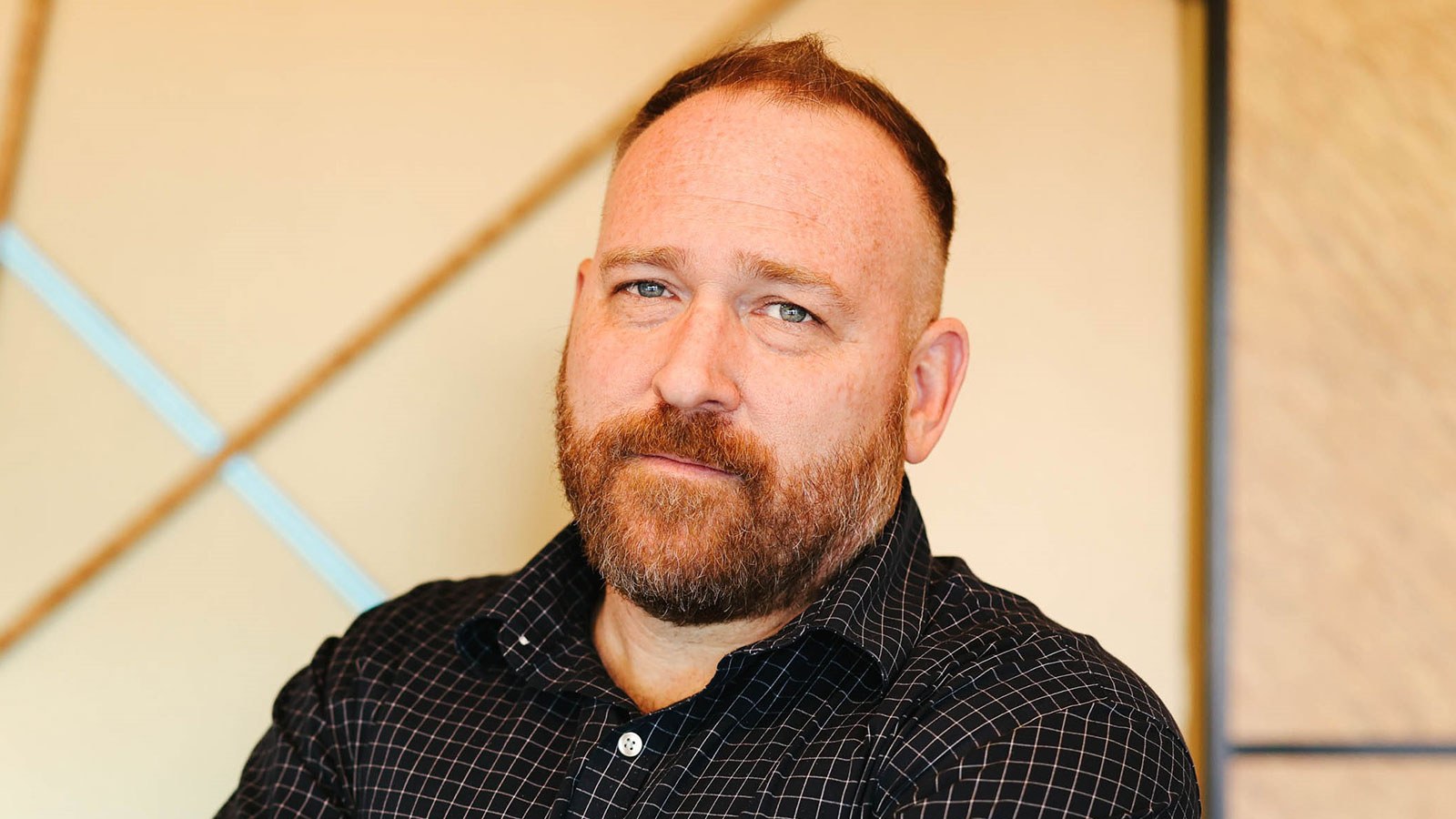 A shoulder-length photo of Ryan Little wearing a dark shirt standing in front of a light-colored background.