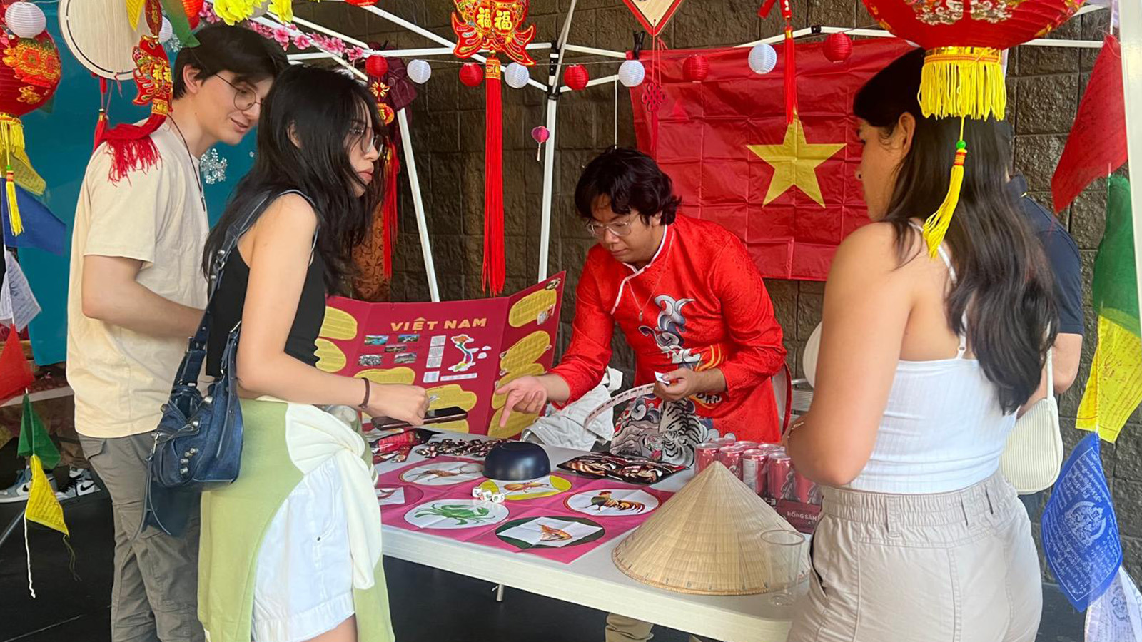 Students gather around a table to play a game at APIC’s night-market event.