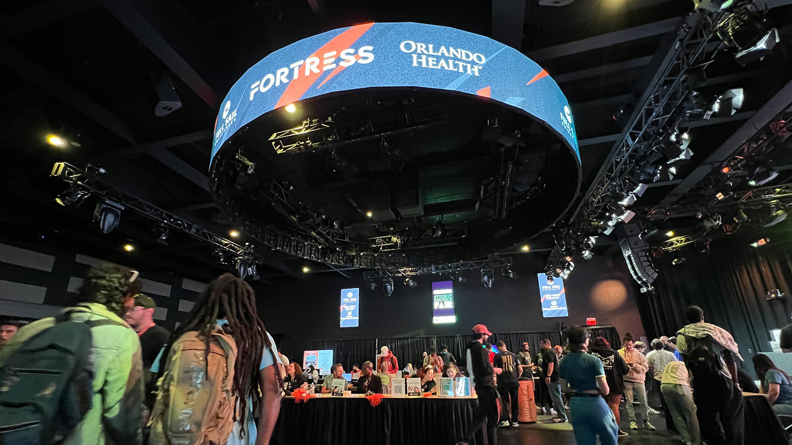 Fish-eye view of the Student Resource Fair. Several lines of booths are set up and many students are walking around the venue.