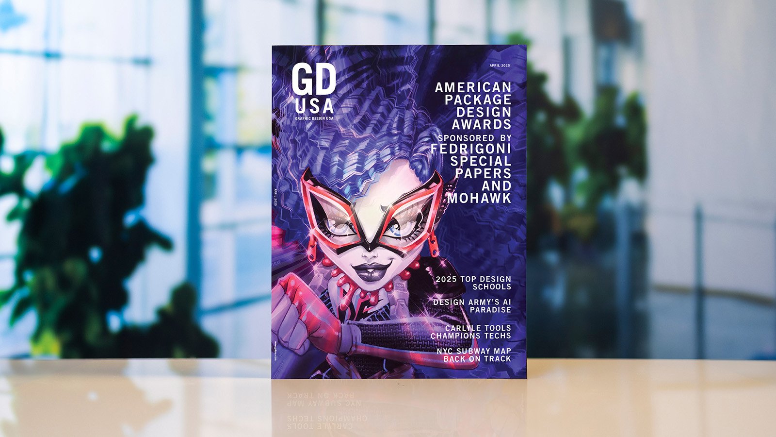 The April 2025 issue of Graphic Design USA. The cover features a cartoon woman with purple hair wearing red glasses and article titles including 2025 Top Design Schools.