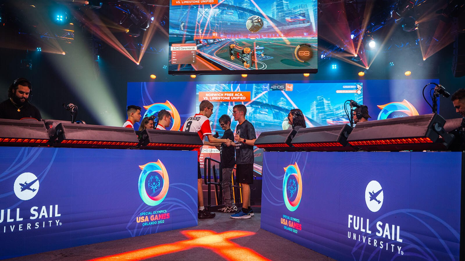 Two Special Olympians shaking hands after a match on stage at the Full Sail University Orlando Health Fortress.