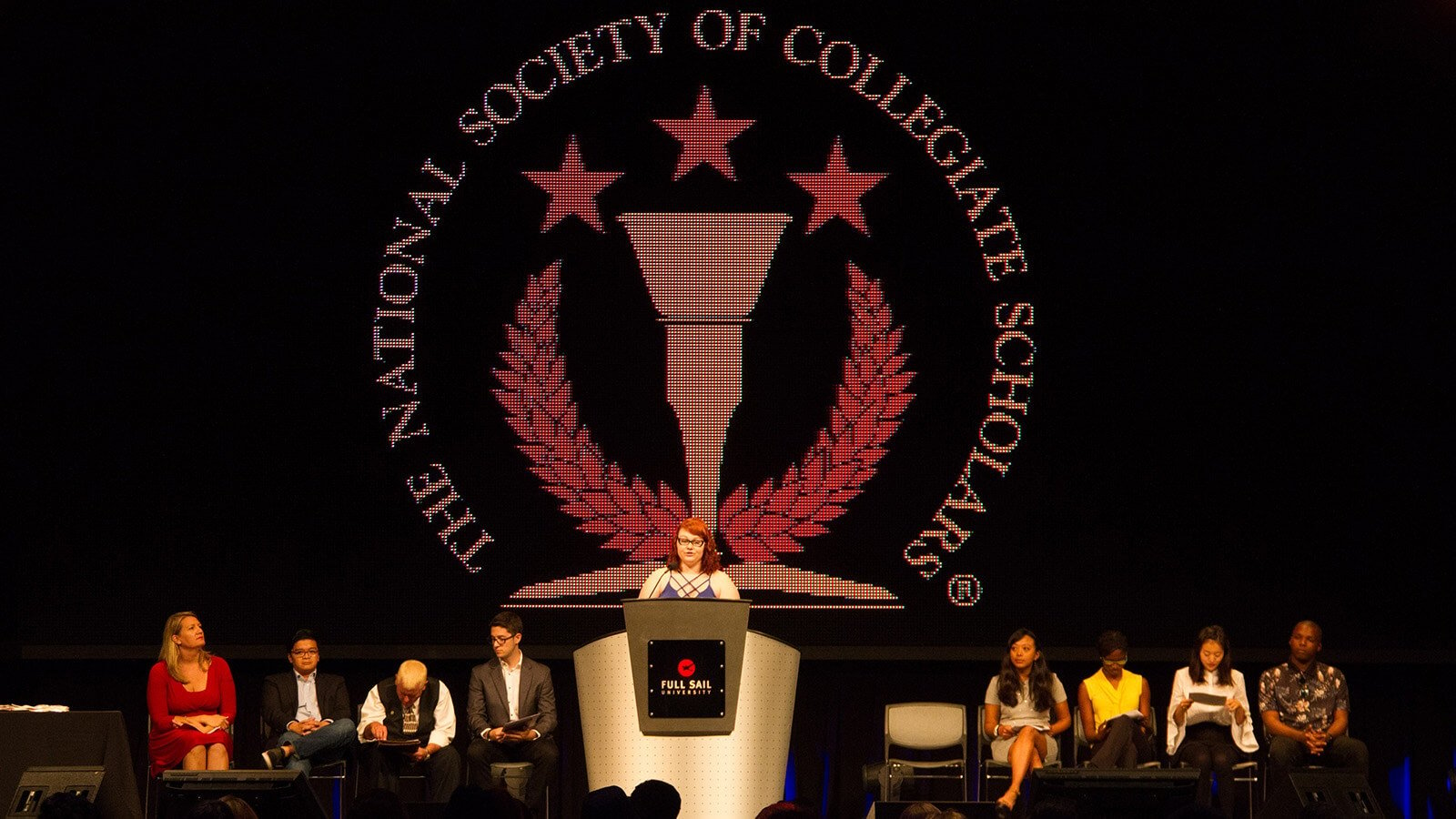 Full Sail’s National Society of Collegiate Scholars chapter members on stage at an NSCS ceremony.