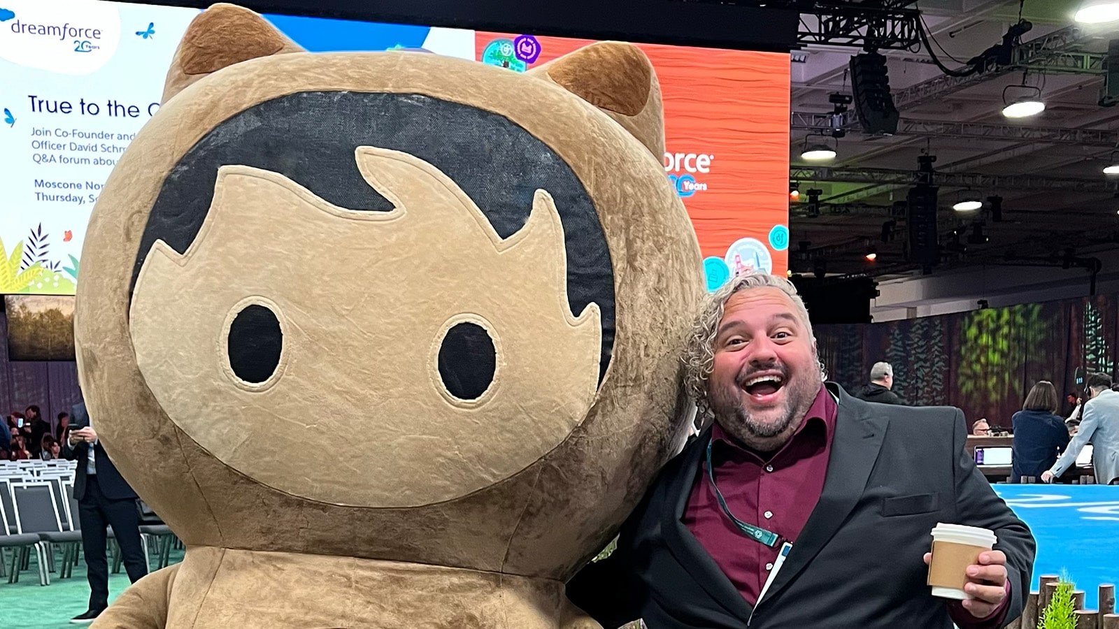 Adam Cipoletti stands with his arm around Astro Nomical, one of Salesforce’s mascots, at the Dreamforce conference.