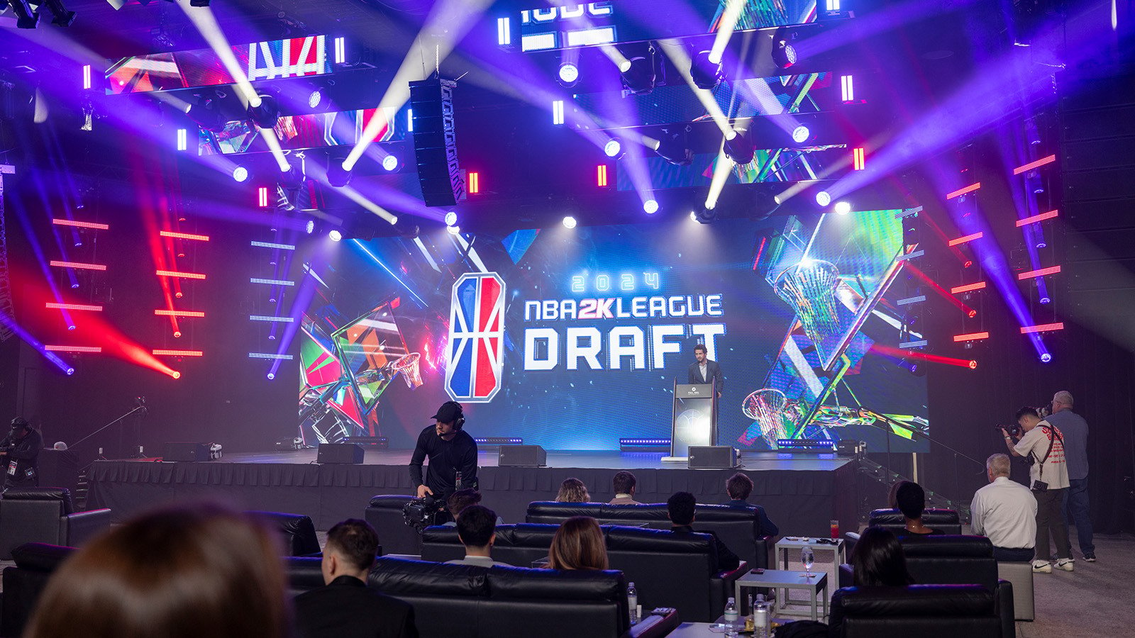 NBA 2K League CEO Andrew Perlmutter on stage in front of a large screen featuring the NBA 2K League Draft logo.