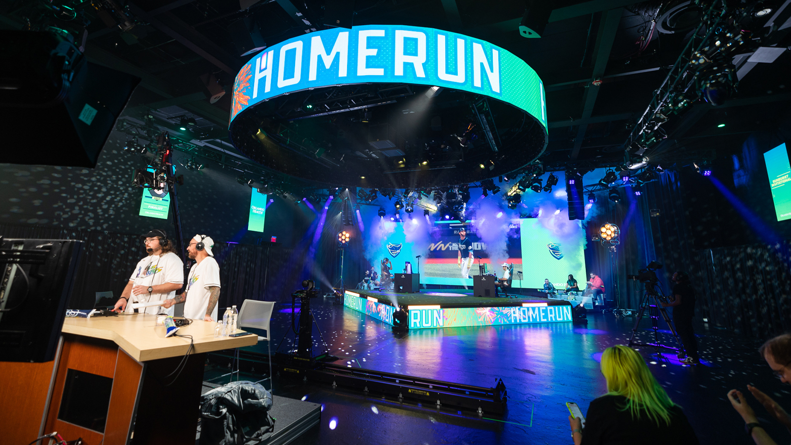 A wide shot of Full Sail’s esports arena during the Sunburst Classic with the words “home run” in large block lettering on an LED screen.