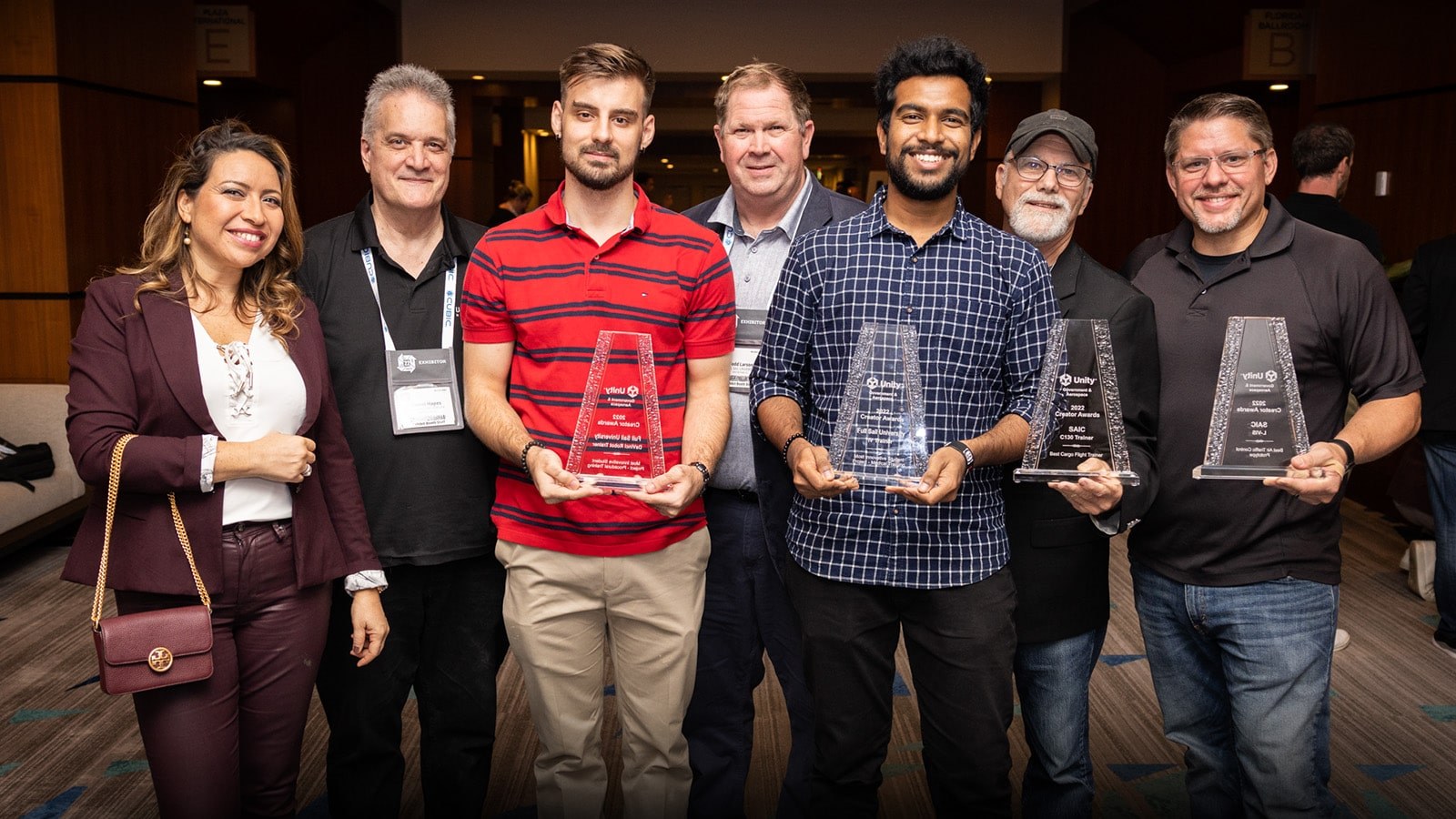 The recipients of the Made with Unity recognition award stand with their statuettes with Full Sail and Advent Health University course and education directors.