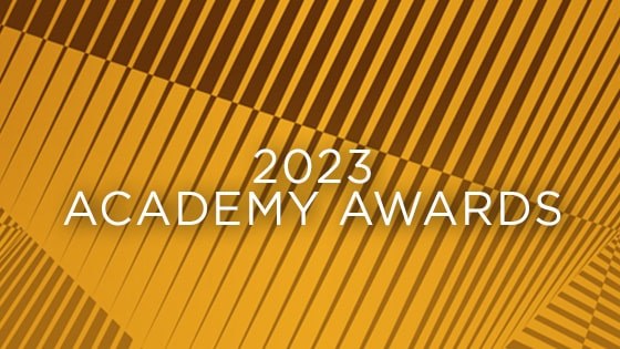 A graphic with the words 2023 Academy Awards in white over a yellow and brown-striped background.