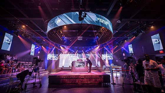 Full Sail’s Fortress dressed for the MCS 25 Kickoff Challenge with dramatic lighting, camera crews, and a small audience watching.