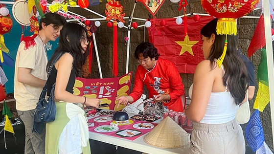 Students gather around a table to play a game at APIC’s night-market event.