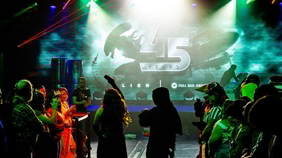 A vibrant crowd in costumes gathers at Full Sail University, celebrating 45 years of the ‘Alien’ franchise for Halloween.