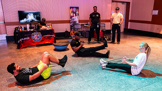 Two staff members take part in a bootcamp style workout instructed by a member of the Orange County Fire Rescue.