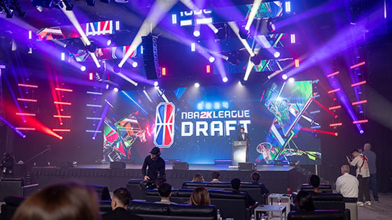 NBA 2K League CEO Andrew Perlmutter on stage in front of a large screen featuring the NBA 2K League Draft logo.