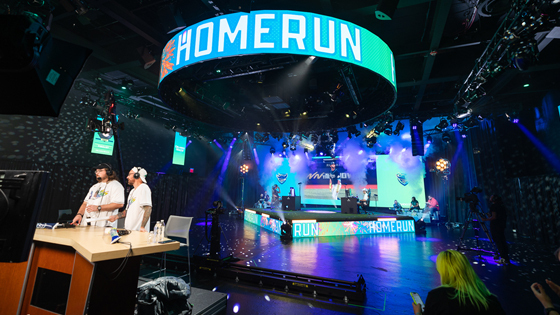 A wide shot of Full Sail’s esports arena during the Sunburst Classic with the words “home run” in large block lettering on an LED screen.