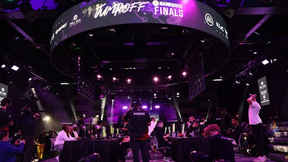 The Full Sail University Orlando Health Fortress esports arena’s main stage and large screens feature Jump Off’s purple and white branding while competitors face-off at gaming stations.