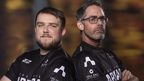 Full Sail Armada staff members Garrett Gajewski and Chris MacMillan stand back-to-back with their arms crossed. They are wearing black and white Armada jerseys.