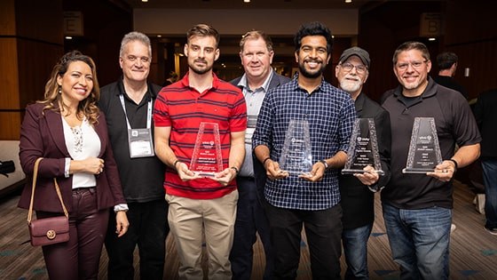 The recipients of the Made with Unity recognition award stand with their statuettes with Full Sail and Advent Health University course and education directors.