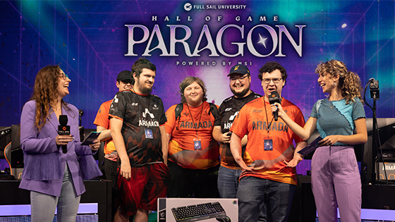 A group of players in various Full Sail Armada team jerseys on stage in the Fortress with hosts, the screen behind them reads “Hall of Game Paragon Powered by MSI.”