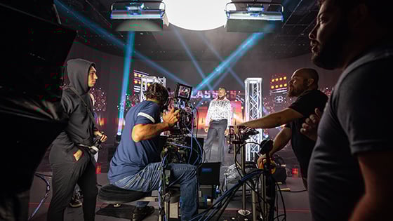 A camera crew films WWE Superstar Big E under bright stage lights for Netflix's RAW Classics at Full Sail University.