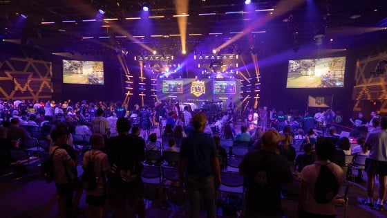 A large crowd in a venue spectating an esports match, a larg LED screen in the front of the room reads ‘North American Finals.’