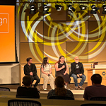 Aidan Kay, Stevie Moore, Ashley Martin, and Joel Sink sit in a row and present to an audience. A large screen behind them displays “Digital Arts & Design Grad Showcase February 2026” and a list of their names.