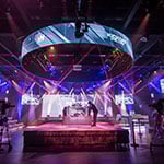 Full Sail’s Fortress dressed for the MCS 25 Kickoff Challenge with dramatic lighting, camera crews, and a small audience watching.