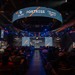 A large audience sits in Full Sail’s esports venue. A stage with a few people standing on it is at the front of the room. The words NACE Awards 2024 are on the wall behind them.