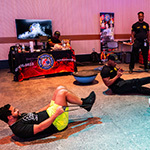 Two staff members take part in a bootcamp style workout instructed by a member of the Orange County Fire Rescue.