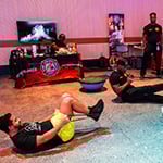 Two staff members take part in a bootcamp style workout instructed by a member of the Orange County Fire Rescue.