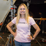 Director Sarah Goras stands confidently while smiling on set during filming in a Full Sail soundstage.