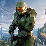 Halo main character Master Chief in signature green armor featuring the number 117 on his left chest plate in white, centered in front of a large grey triangular space ship with the words ‘Halo Infinite’ stylized in the bottom left corner.