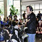 Magic Gaming’s coach and players at gaming stations while a crowd looks on in the background.