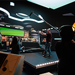 Space Pups’ director Jason Murphy stands onstage in a virtual spaceship set. He is talking to a crew member while another crew member holds a boom mic.