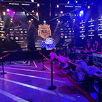 The stage in Full Sail’s Live Venue appears in the background of a row of players seated at gaming stations during the XP League North American Finals.