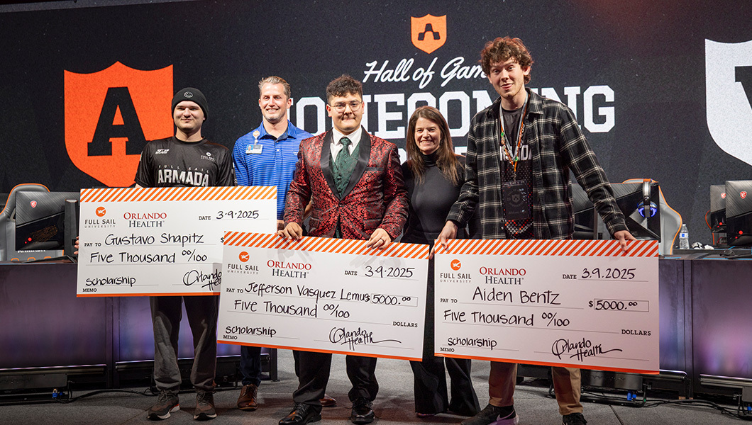 Three students hold giant scholarship checks and pose with an Orlando Health representative and the director of esports at Full Sail.