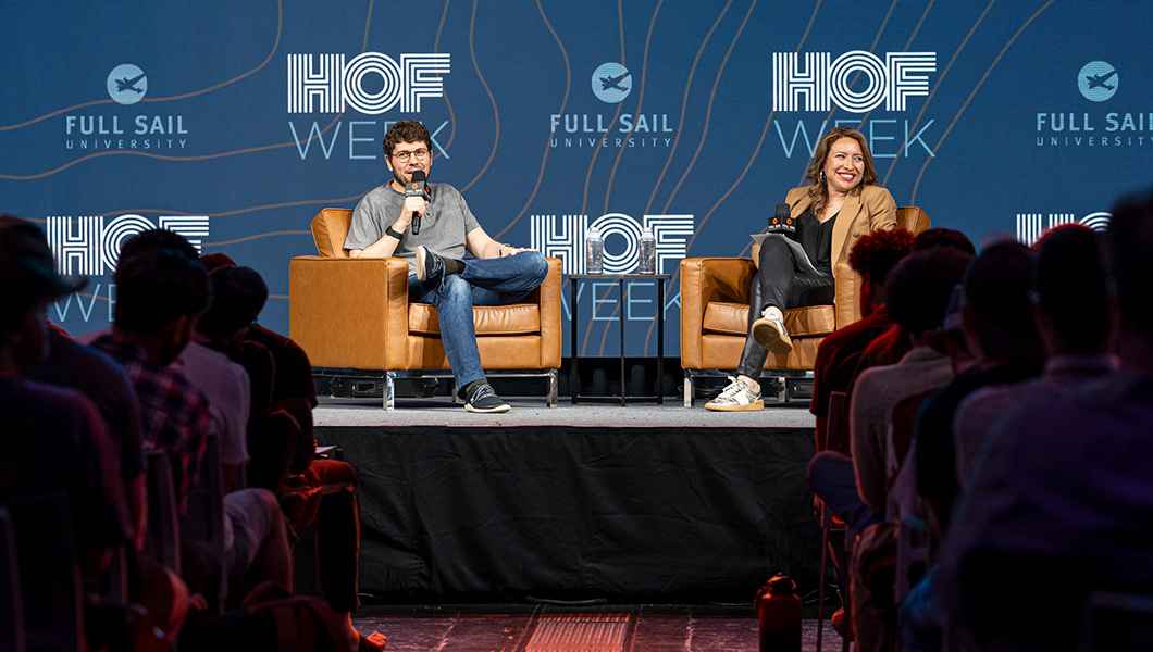 Jason Citron and a moderator sit in chairs onstage in front of an audience. Jason holds a microphone.