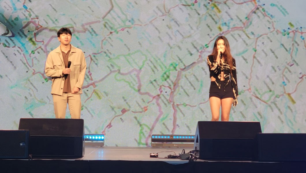 Two people standing on a stage while holding microphones and singing a song.