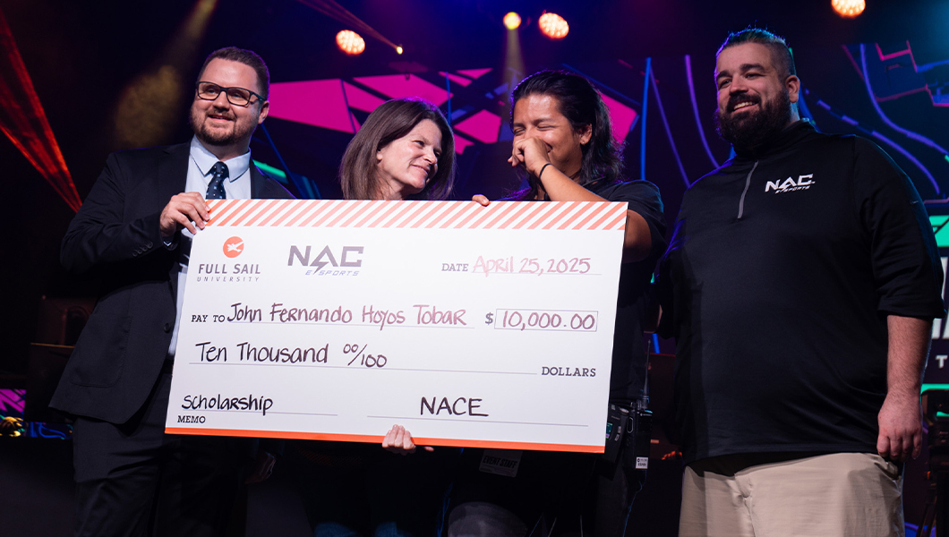 John Fernando Hoyos Tobar stands next to three Full Sail and NACE staff. They are holding a giant check for $10,000.
