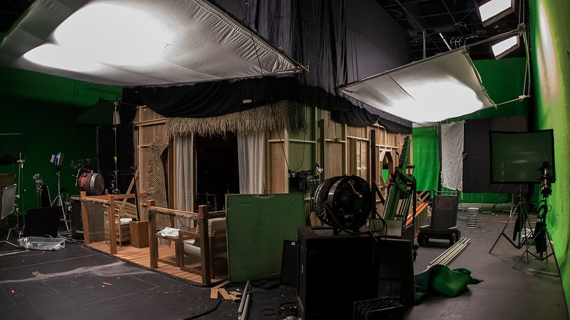 A sound stage with a wooden set resembling a seaside villa.