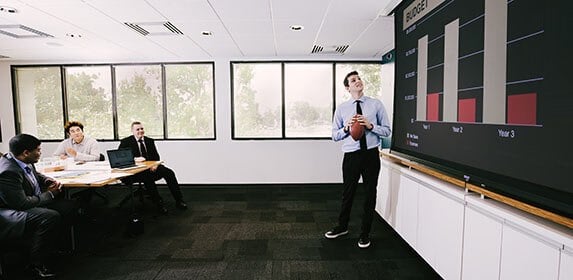 A Sports Management student presents a yearly business plan to a room of peers.