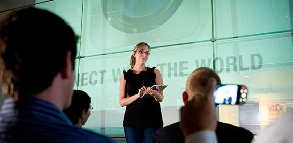 With an iPad, an instructor teaches an assembled class while a student records the lesson on their phone.