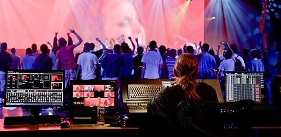 A Live Events student uses audio and light controls to transform a live concert into an experience for attendees.