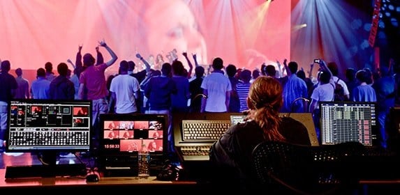 A Show Production student uses audio and light controls to transform a live concert into an experience for attendees.