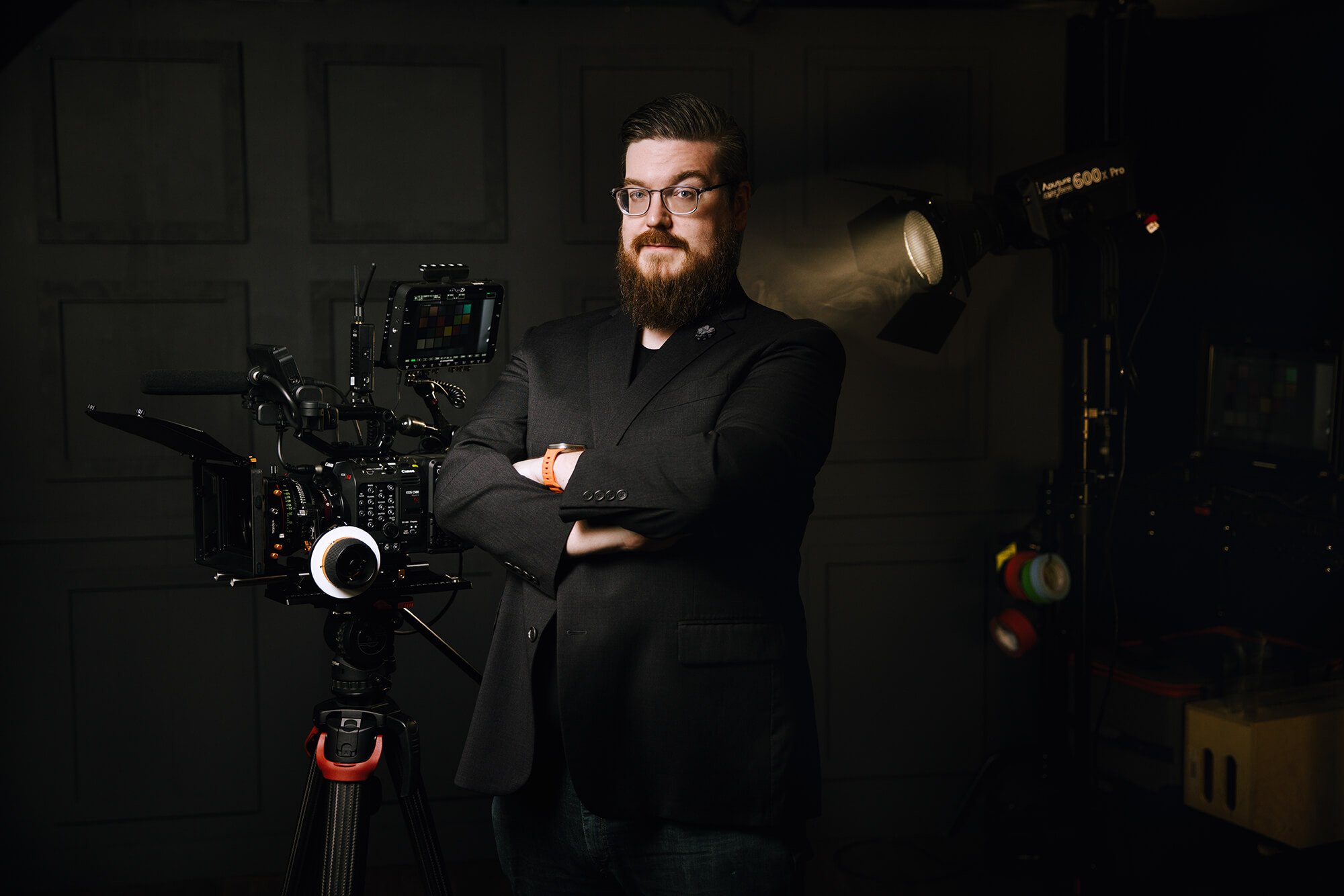 Photograph of Stephen Beres with his arms crossed, standing around filmmaking equipment.